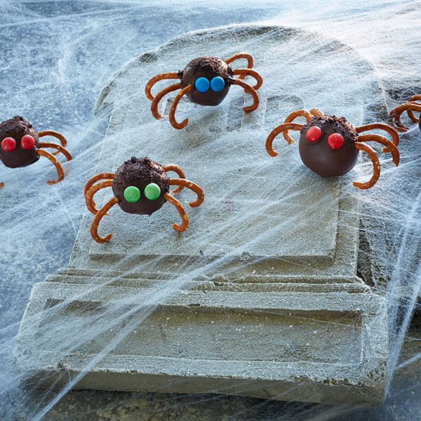Chocolate covered peanut butter spiders with pretzel legs and chocolate candy eyes.