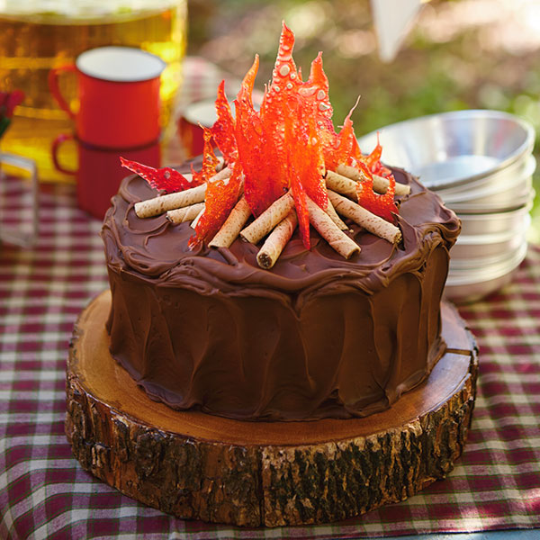 Campfire cake with orange hard candy as flames and rolled wafers as logs.