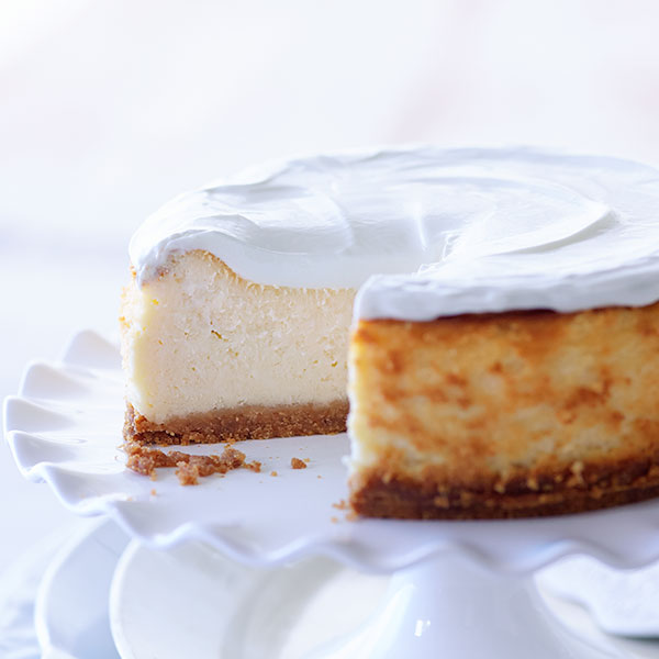 Vanilla cheesecake with a golden exterior, topped with sweetened sour cream.