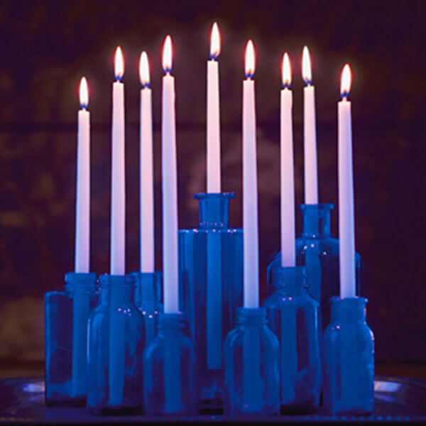 Elegant Hanukkah menorah made with blue glass bottles.