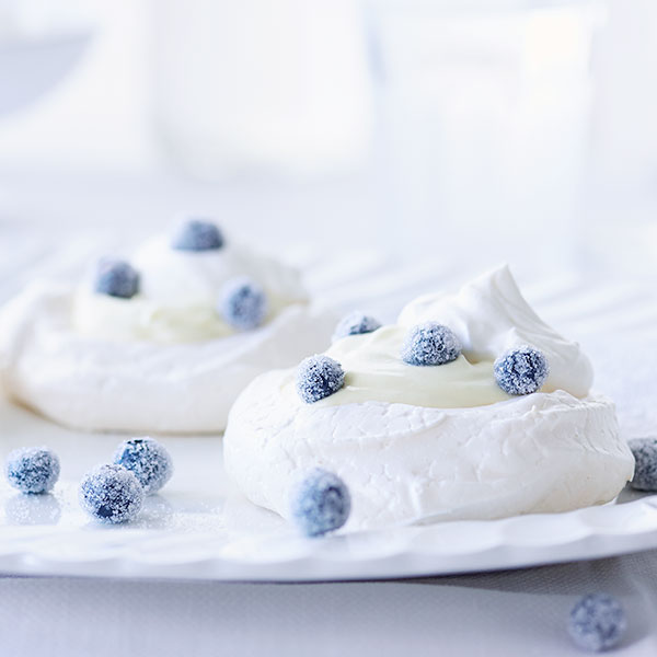 Light, fluffy lemon meringue cookies with sugared blueberries on top.