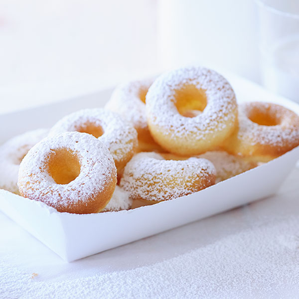 Chinese five spice donuts shaped in small rings and coated in powdered sugar.