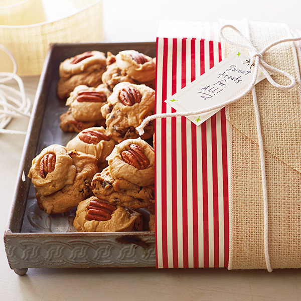 Brown sugar cookies in a gift tray with pecans and a buttercream frosting.