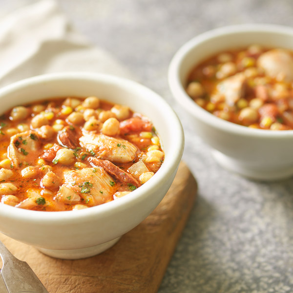 Hearty, chunky chicken and chickpea stew in a white bowl.