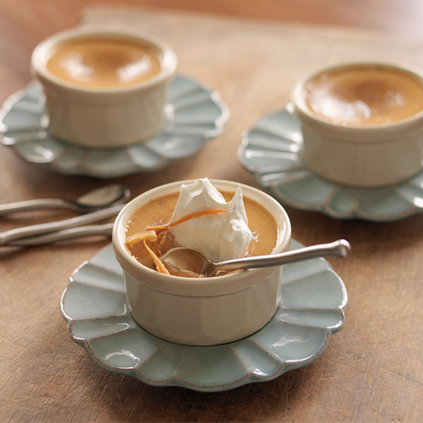 Creamy sweet potato custard with a dollop of whipped cream on top.