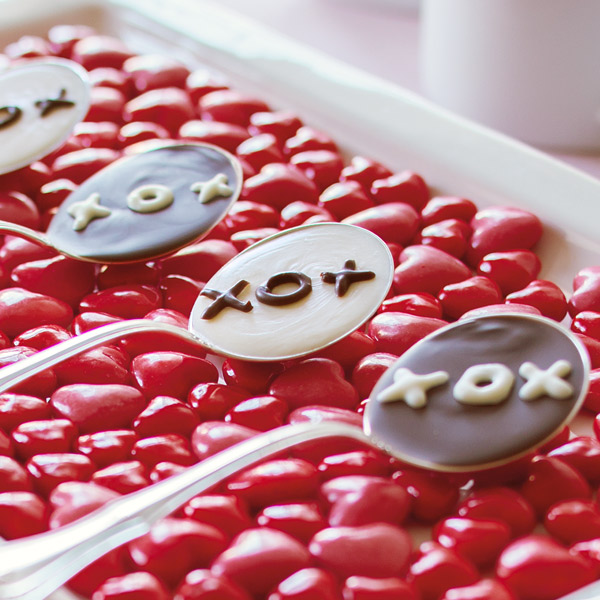Chocolate spoons with XOX written as decoration in a contrasting color.