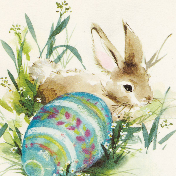 Watercolor of a rabbit in the grass with a blue, purple and green Easter egg next to it.