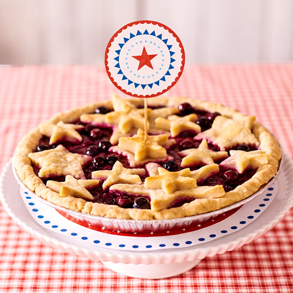 Homemade blueberry pie with star-shaped crust pieces and a red, white and blue pie topper.