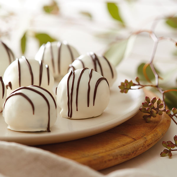 Brownie balls coated in white chocolate and drizzled with dark chocolate.