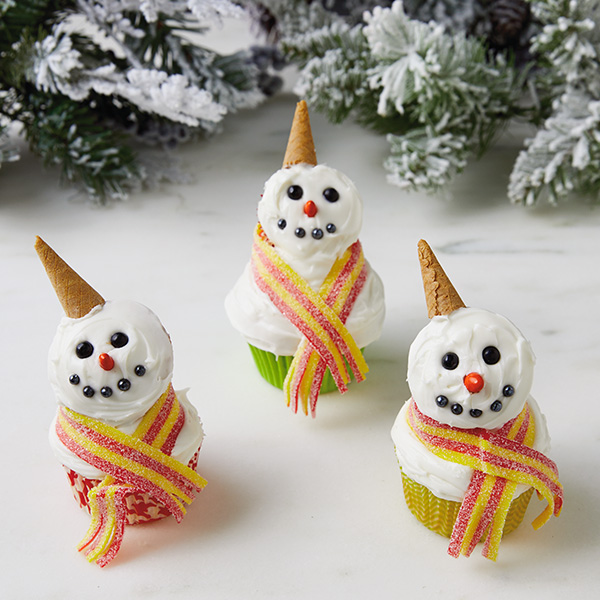 Snowman cupcakes with mini cone hats and sour belt candy scarves.