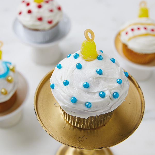 Christmas ornament cupcakes decorated with chocolate pearls and candy to look like ornaments.