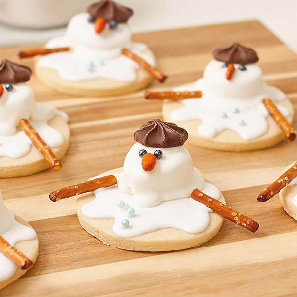 Melted snowman cookies with pretzel stick arms and a chocolate star candy hat.