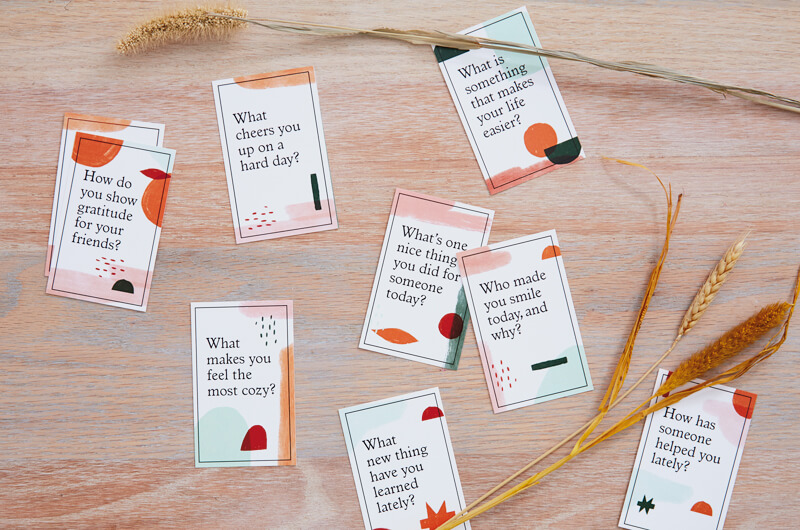 Gratitude conversation starter cards on table with wheat