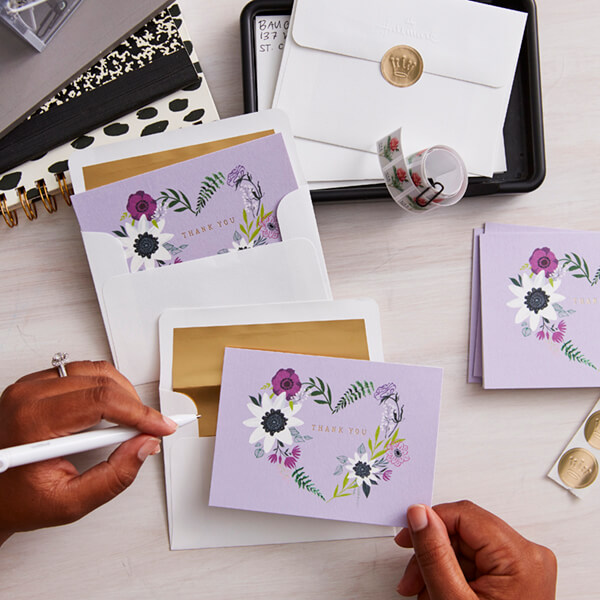 A woman writing bridal shower thank-you notes.
