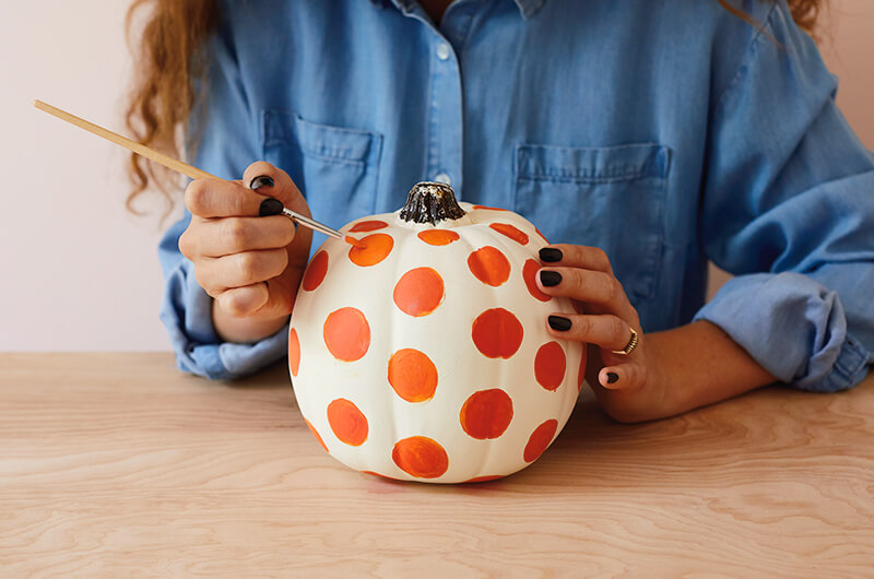 Painting a pumpkin with polka dots