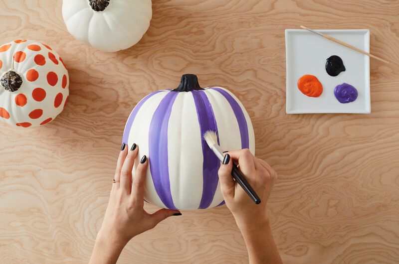 Painting a pumpkin with stripes