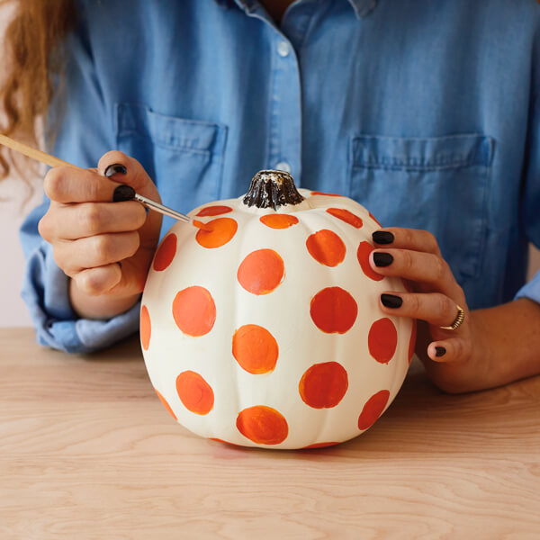 Crafting a painted pumpkin with polka dots