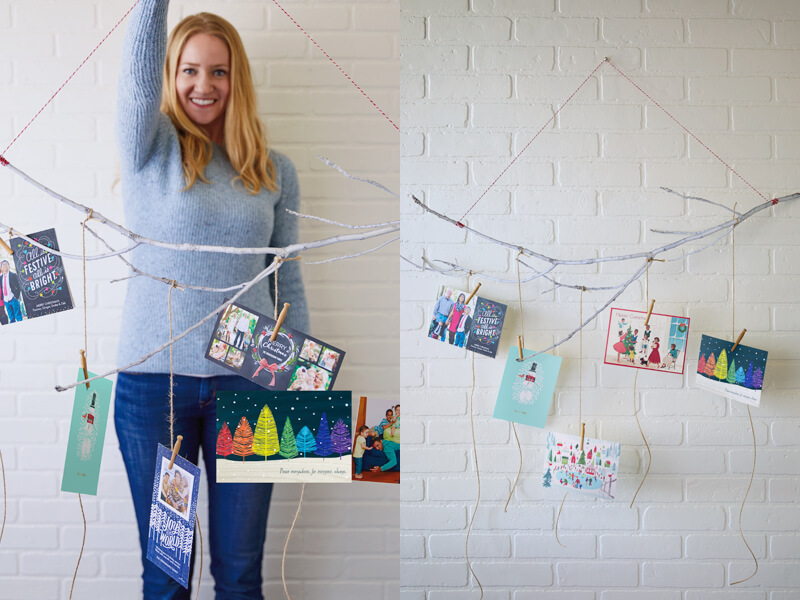 Christmas card display using a winter branch and photos hanging off of it.