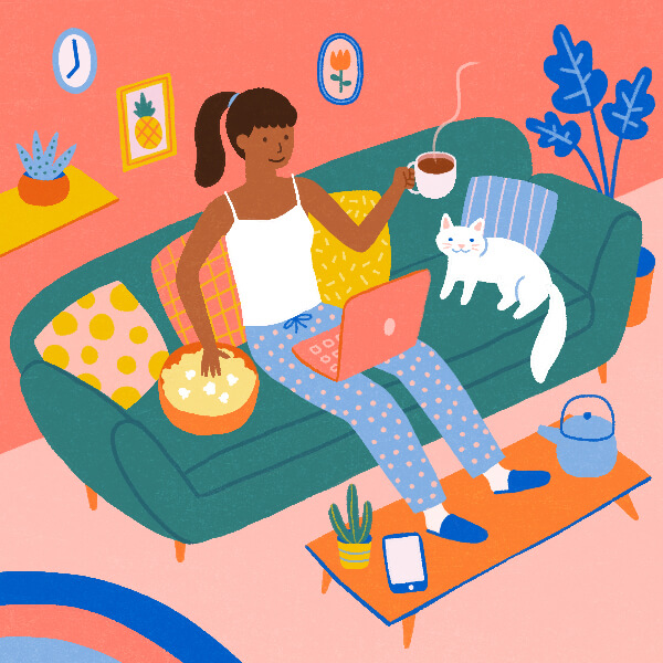 A woman on the couch eating popcorn, drinking coffee and watching a show on her laptop.