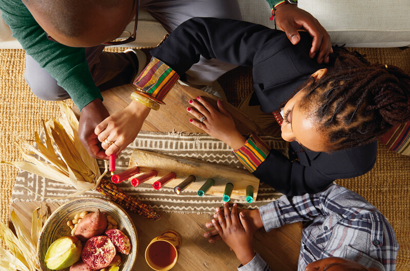 A person lighting candles for Kwanzaa.