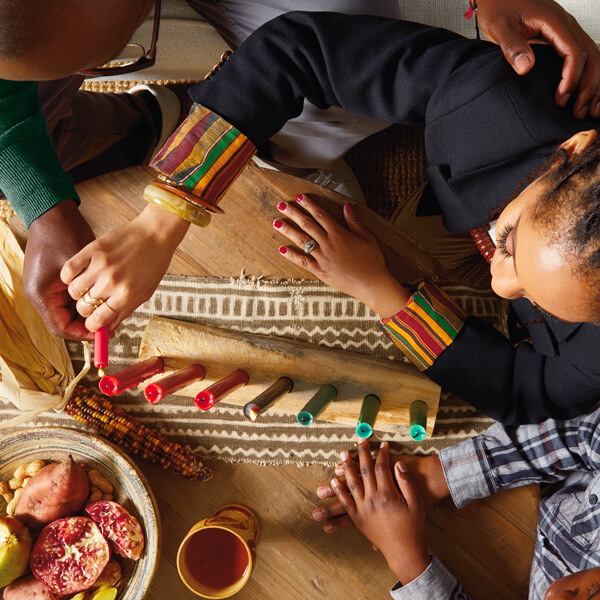 A person lighting candles for Kwanzaa.