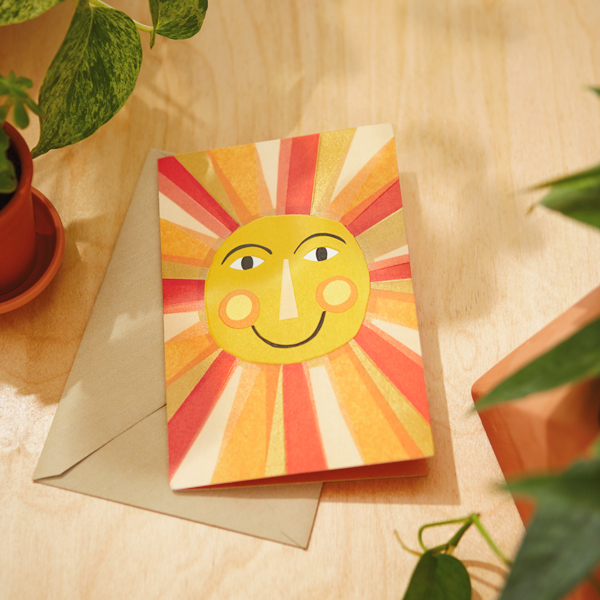 Encouragement Card with a sun on it and an envelope on a desk with plants