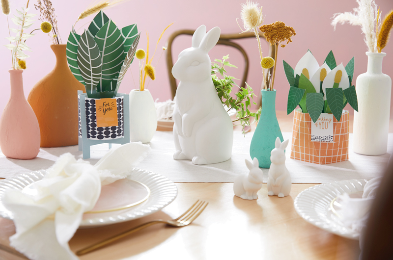 Easter table with cards, bunnies, vases and flatware