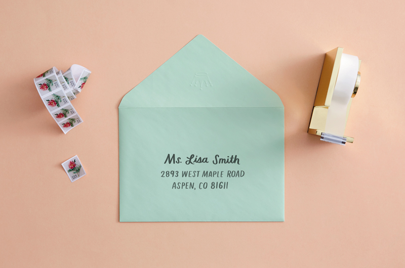 envelope on desk with pen that reads