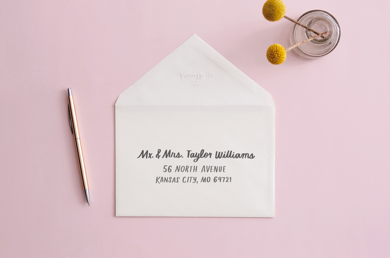 envelope on desk with pen that reads