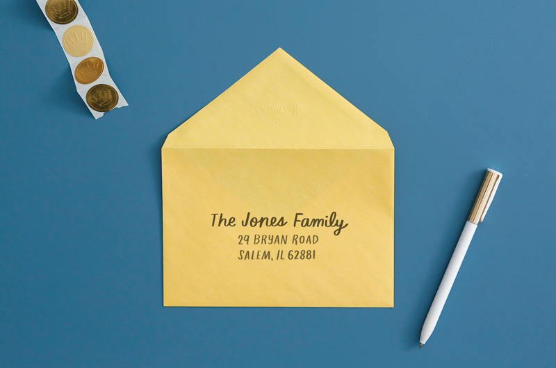 envelope on desk with pen that reads