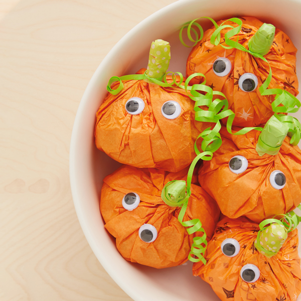 Pumpkin treat bags in a bowl for Halloween