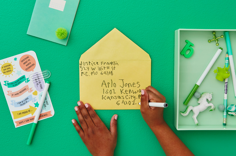 Kid writing address on envelope