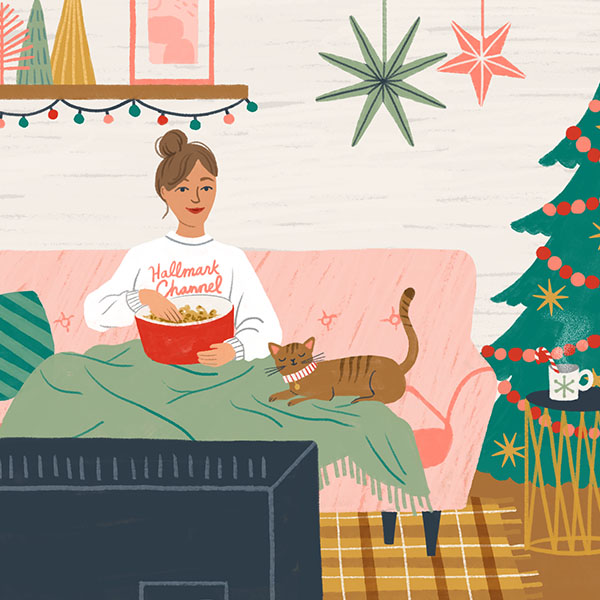 A woman watching Hallmark Christmas movies with her cat and festive decor