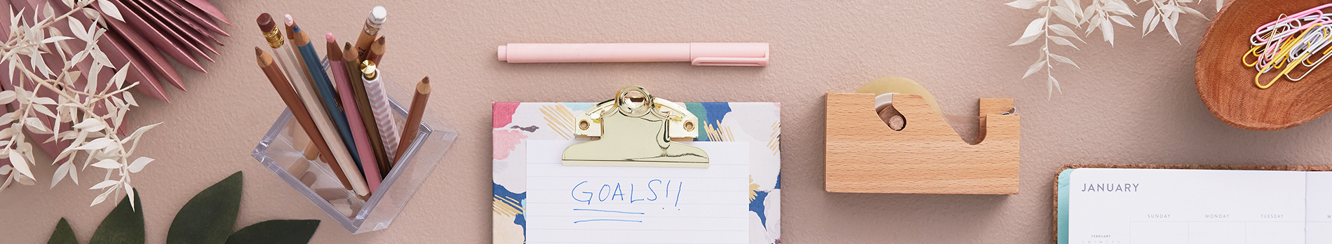 New Year's background with a calendar planner, office supplies, and a notepad that says 