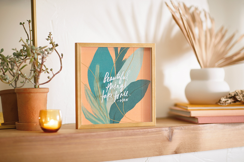 A framed sentiment from the Morgan Harper Nichols Real Stories Collection on a shelf that reads,