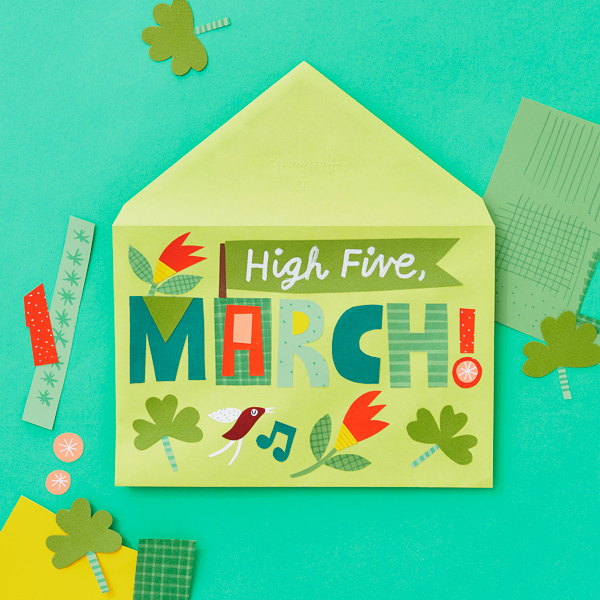 A cut paper composition on a light green envelope that reads, 