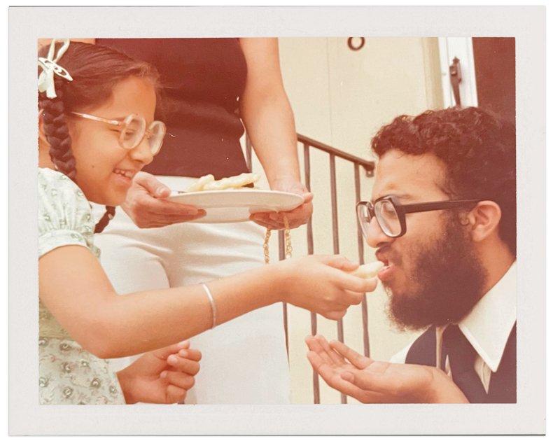 A little girl feeds her older brother sweets in celebration of Raksha Bandhan.