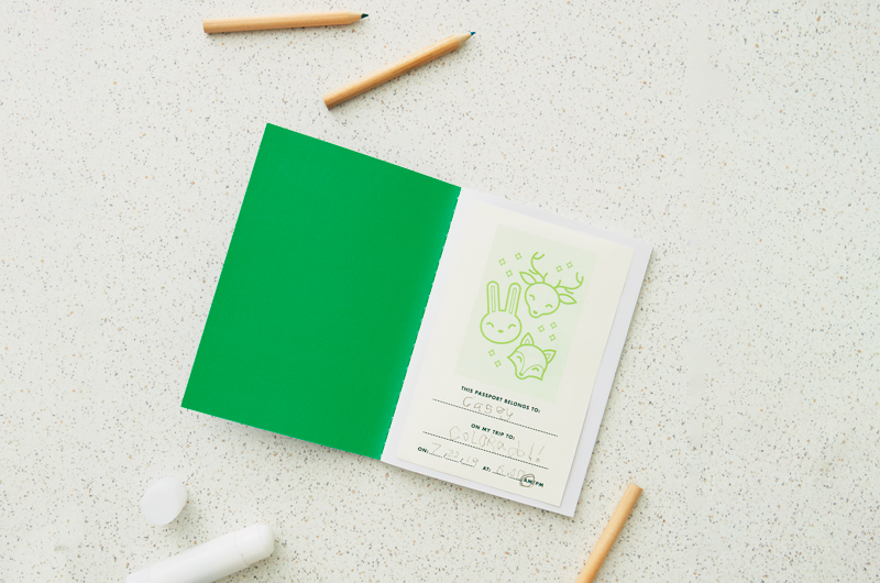 A DIY travel journal, opened to the first page and surrounded by golf pencils.