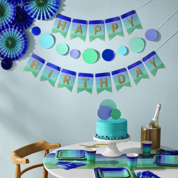 A birthday table featuring the Blue Rainbow Basic Kit and Decor Kit from Color Pop. A banner in the background reads,