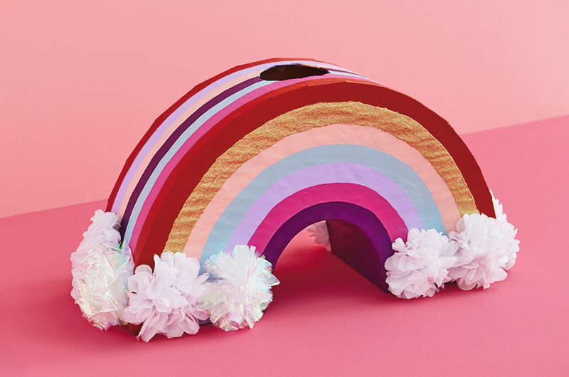 A valentine box shaped like a rainbow with clouds at the end.