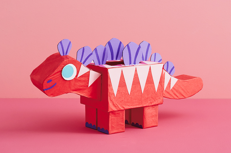 A valentine box shaped like a red, pink and purple stegosaurus.