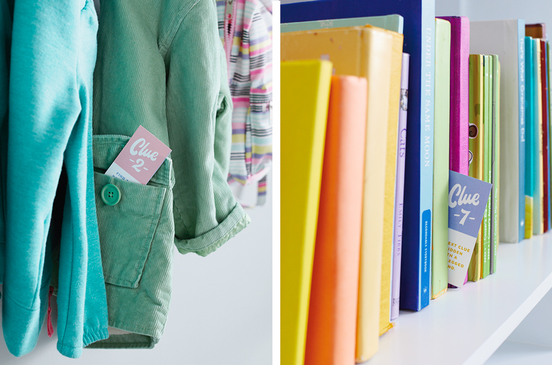 Scavenger hunt clues hidden in the pocket of a hanging coat and sticking out of a row of books on a shelf.