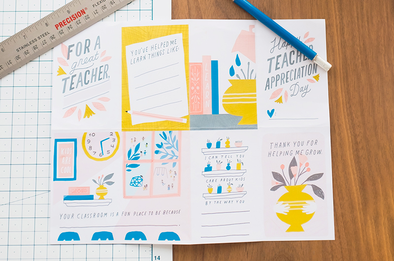 Our free DIY teacher appreciation printable lays on a table with a cutting mat, a ruler and a pencil, with creases from folding in it.