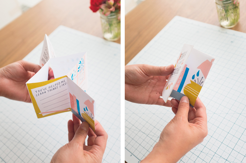 A pair of hands assembles the free DIY teacher appreciation zine, folding it along the creases made previously.