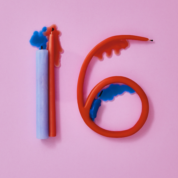 Wax candles melted and shaped into the number 16, symbolizing the traditional material for 16th wedding anniversary gifts, which is wax.