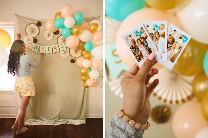 A woman hangs a lettered Celebrate! banner that reads,