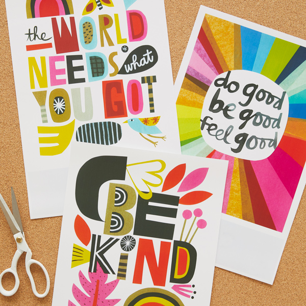 Our three free printable classroom posters are printed and lay on a cork tile next to a pair of scissors with white handles; the posters read,