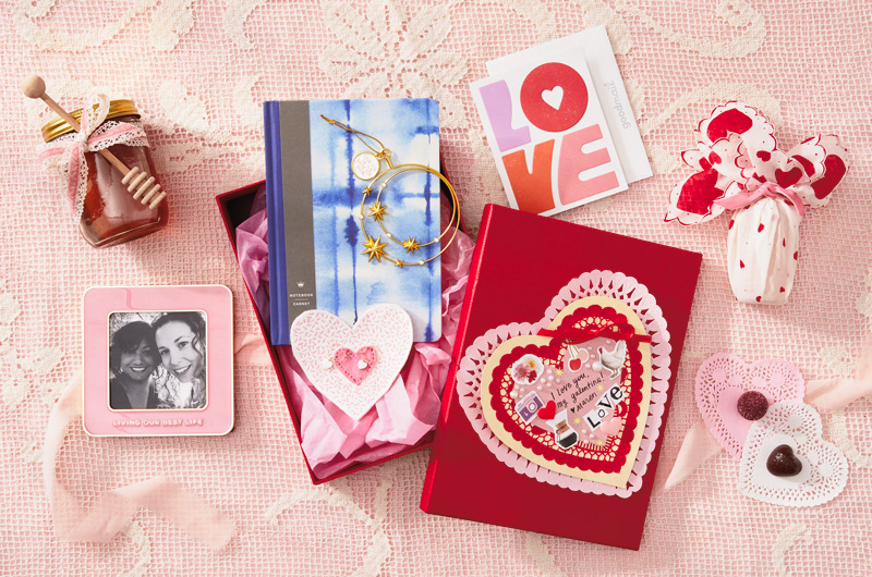 A collection of gift ideas for Galentine's Day that includes a pink picture frame, a journal, a gold Keepsake Ornament, and a greeting card with the word