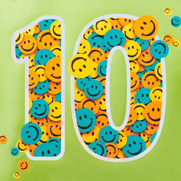 The number ten is cut out of a bright green background; filling in the cutout numbers one and zero are pieces of smiley-face confetti.