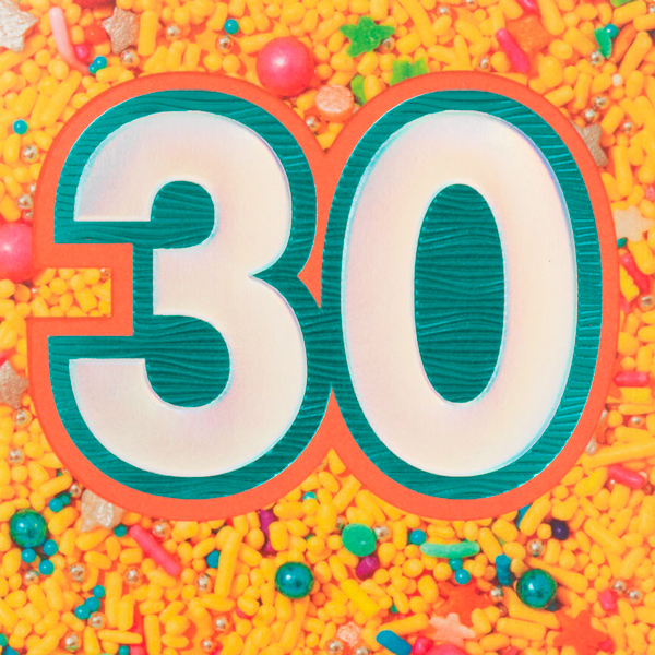 The number thirty is cut out of a photo filled with sprinkles of different colors and shapes.